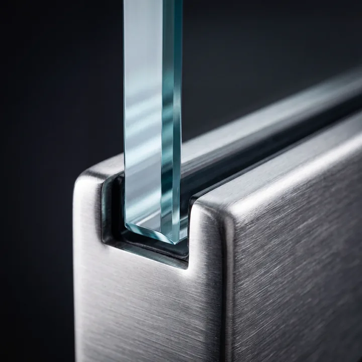 Close-up of a smooth glass edge set in a steel channel